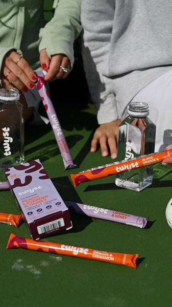 This creative showcases electrolyte drink mix stick packs and water bottles on a tennis court, emphasizing active lifestyle and wellness benefits.
